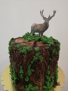 there is a cake that has been decorated with green grass and a deer figurine on top