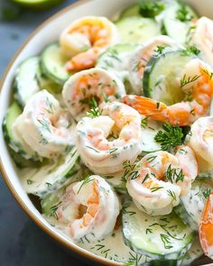 a bowl filled with shrimp and cucumber salad