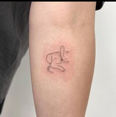 a woman's arm with a small dog tattoo on the left side of her leg