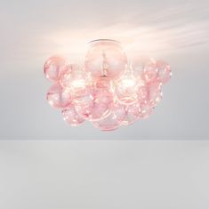 a light that is hanging from the ceiling with some bubbles on it and lights in front of it