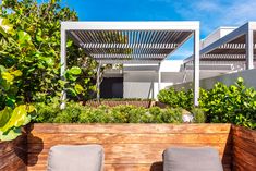 two gray chairs sitting on top of a wooden planter