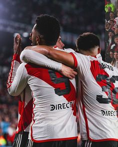 two soccer players hugging each other on the field