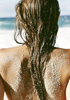 the back of a woman's head with wet hair and water all over her body