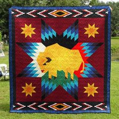 a colorful quilt on display in the grass