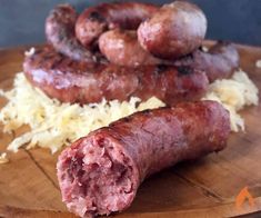 two sausages on a cutting board with grated parmesan cheese