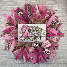 a pink and leopard print wreath on a brick wall with the words faith love hope