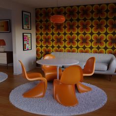 an orange and white living room with modern furniture, rugs and wallpaper on the walls