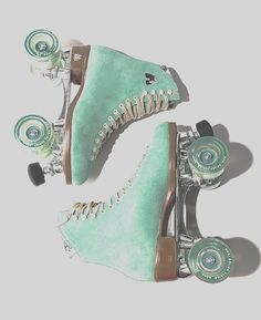 two green roller skates with wheels are shown against a white background and one is upside down