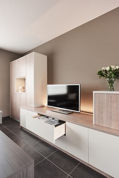 a living room filled with furniture and a flat screen tv on top of a wooden shelf