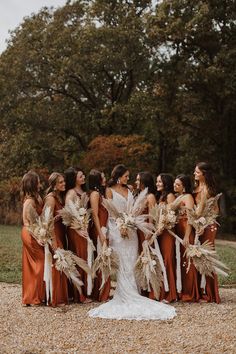 a group of women standing next to each other wearing dresses and holding bouquets in their hands