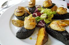 a white plate topped with lots of different types of food on top of a table