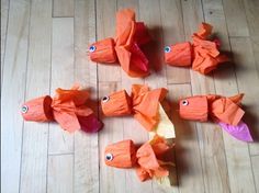 several orange pieces of paper with eyes on them sitting on the floor next to each other