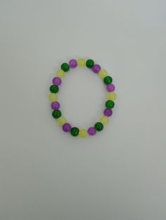 Glass beaded bracelet- 8 neon yellow beads, 8 green beads and 8 purple beads long. 7 inches long. Elastic stretchy band. The perfect piece for your jewelry collection. Neon Round Bead Bracelets For Gifts, Neon Beaded Bracelets Gift, Neon Bracelets With Round Beads For Gift, Neon Beaded Bracelet Gift, Adjustable Lime Green Beaded Bracelets, Multicolor Stretch Jewelry With Round Beads, Stretch Multicolor Round Beads Jewelry, Colorful Beaded Lime Green Jewelry Gift, Lime Green Colorful Beads Jewelry As Gift