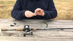 a man sitting at a picnic table holding a fishing rod