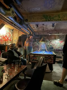 some people are playing games in a room with graffiti on the walls and flooring