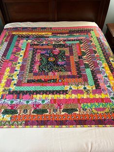 a bed with a colorful quilt on top of it