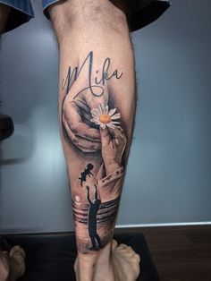 a man's leg with a hand holding a flower and the words mela on it