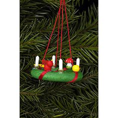 an ornament hanging from a christmas tree decorated with candles and birds on it