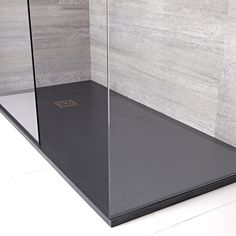 a glass shower stall in a bathroom with tile walls and flooring on the wall