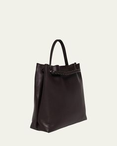 Bottega Veneta "Andiamo" tote bag in silky calf leather     Top handle     Sliding shoulder strap with knot hardware accent     Can be worn as a top handle or shoulder bag     Open top with magnetic closure     Interior, one zip pocket and two slip pockets     Lining: Suede    Feet protect bottom of bag     Approx. 9.8"H x 12.5"W x 4.3"D    Made in Italy Bottega Veneta Andiamo, Open Top, Leather Tote Bag, Leather Top, Magnetic Closure, Bottega Veneta, Leather Tote, Top Handle, Leather Shoulder Bag