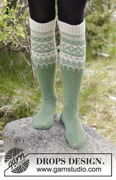 the legs of a woman wearing green socks and knee high socks with white lace on them