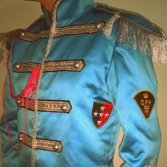 a man wearing a blue jacket with patches on it