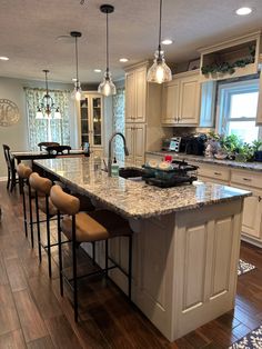 a large kitchen with an island in the middle and lots of stools around it