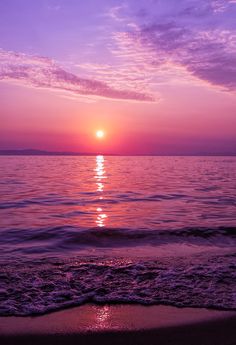 the sun is setting over the water at the beach