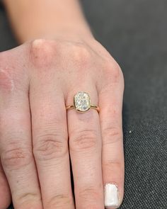 a woman's hand with a yellow diamond ring on her left hand and a white background