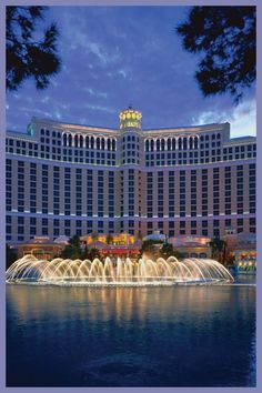 the fountains are lit up in front of the hotel