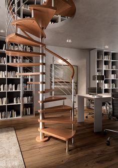 a spiral staircase in the middle of a room with bookshelves and desks