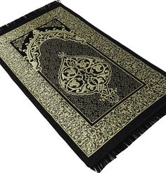 a black and gold rug with an ornate design on the bottom, in front of a white background