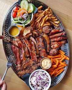 a platter filled with meat, french fries and coleslaw