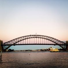 a large bridge spanning the width of a body of water with a boat on it