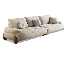 a white couch with pillows on it sitting in front of a white wall and floor