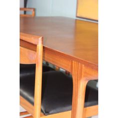 a wooden table with two black chairs next to it