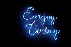 a neon sign that says enjoy today in blue and white letters on a black background