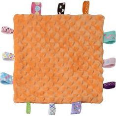 an orange rug with many different colored hair clips on the top and bottom of it