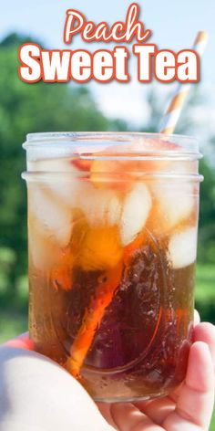 a person holding a mason jar filled with peach sweet tea and ice cubes, text overlay reads the best homemade peach sweet tea