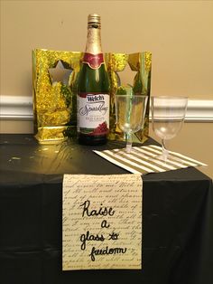 a bottle of wine sitting on top of a table next to glasses and napkins