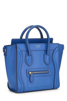 Find CELINE Luggage Nano Bag on Editorialist. The Céline Luggage Nano Bag is crafted from drummed calfskin leather. It features a top handle, a detachable and adjustable shoulder strap, a push lock closure, and a gold-tone hardware. The bag also includes a small pocket at the back and a zipped pocket on the front. Blue Calf Leather Shoulder Bag With Detachable Strap, Blue Calf Leather Bag With Gold-tone Hardware, Blue Calf Leather Bag With Detachable Strap, Chic Blue Calf Leather Bag, Blue Textured Calf Leather Bag, Blue Luxury Textured Leather Satchel, Luxury Blue Textured Leather Satchel, Tas Celine, Celine Nano Luggage