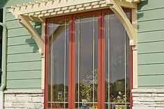 an orange and red window sitting on the side of a green building