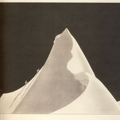 a black and white photo of an iceberg with snow on the ground below it