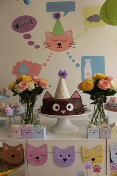 a table topped with cake and flowers on top of a white tablecloth covered in paper