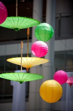 colorful paper lanterns hanging from strings in front of a building