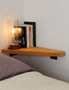 a bed room with a book shelf on the wall and a lamp next to it