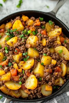 a skillet filled with ground beef and potatoes