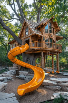 an orange slide in front of a tree house