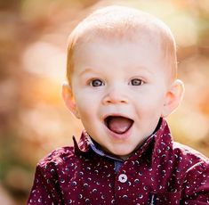 a young boy with his mouth open and eyes wide open, looking at the camera