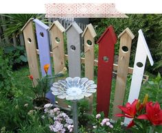 an assortment of bird houses and flowers in a garden